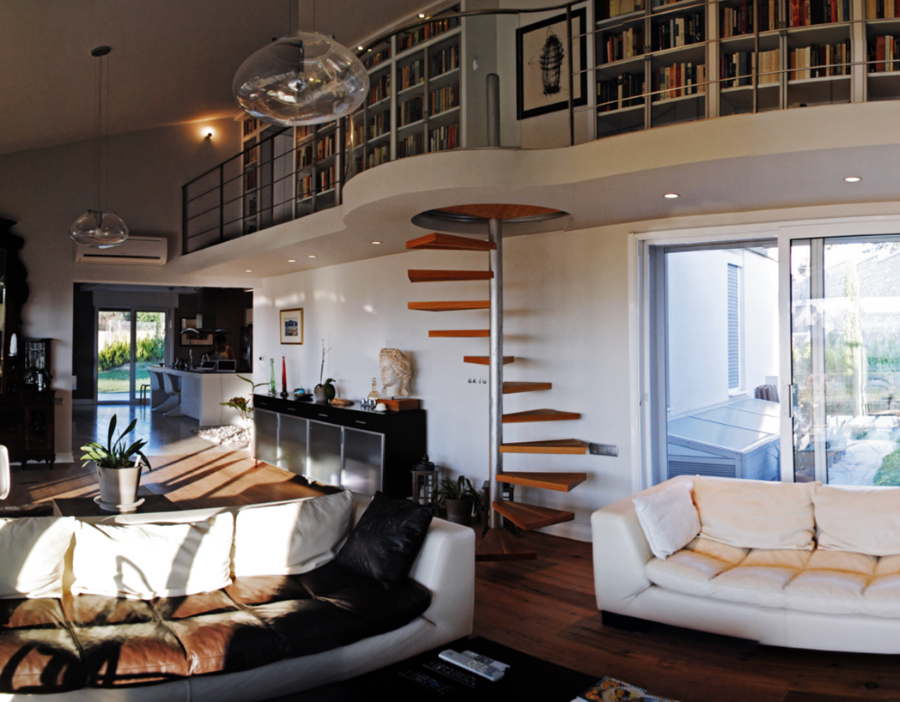 Design4room  Architecture & Interior Design Balcioglu House living room, featuring 2 whites sofas surrounding a center table and a fire place, we also have some spiral stairs and two suspension lights, this time with the view from the sofas.