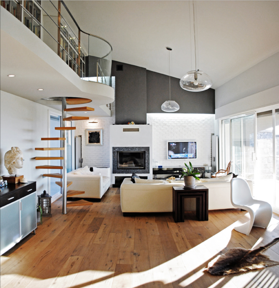 Design4room  Architecture & Interior Design Balcioglu House living room, featuring 2 whites sofas surrounding a center table and a fire place, we also have some spiral stairs and two suspension lights.