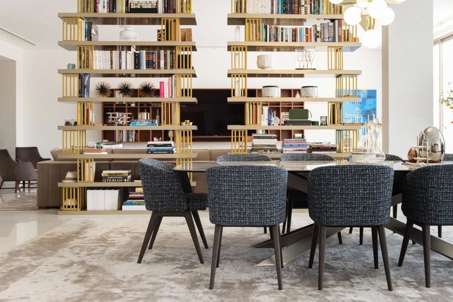 A dining room with bespoke upholstery and dining table surrounded by a custom made shelves.   