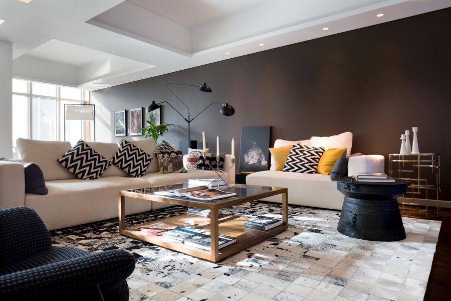A living room with a lot of colour, with a rug, a some bespoke sofas and a couple of center tables.