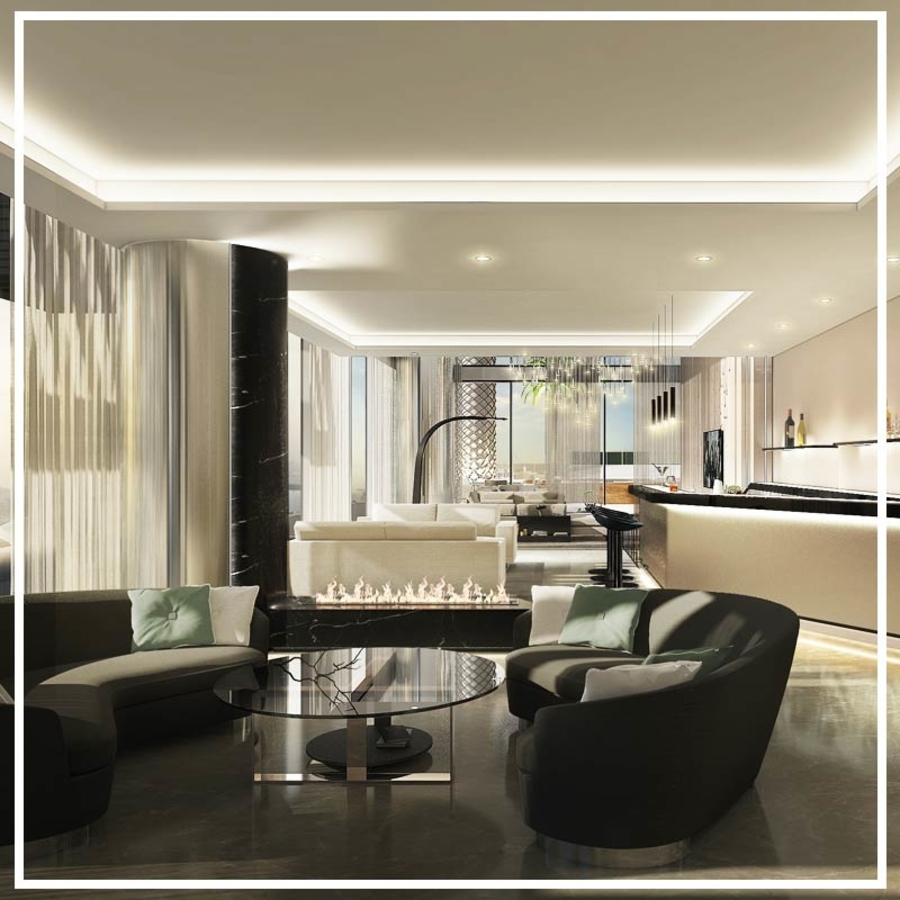 A living room with light and dark tones separated by a fireplace with center tables and bespoke upholstery.