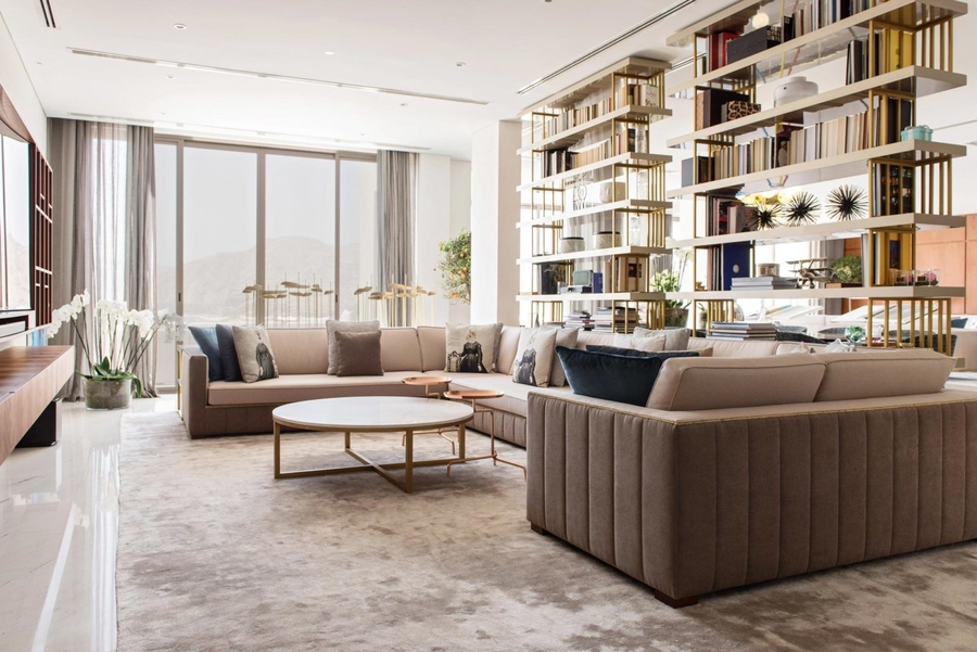 A living room with earth colours completed with a custom sofa and a center table.