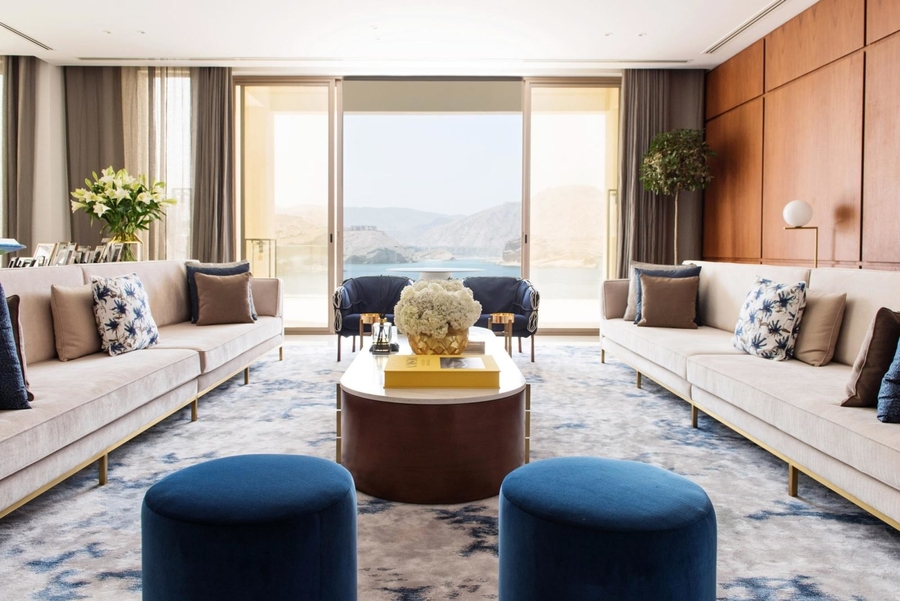 A living room decorated with earth colours accompanied by some blue details competed with some bespoke upholstery.