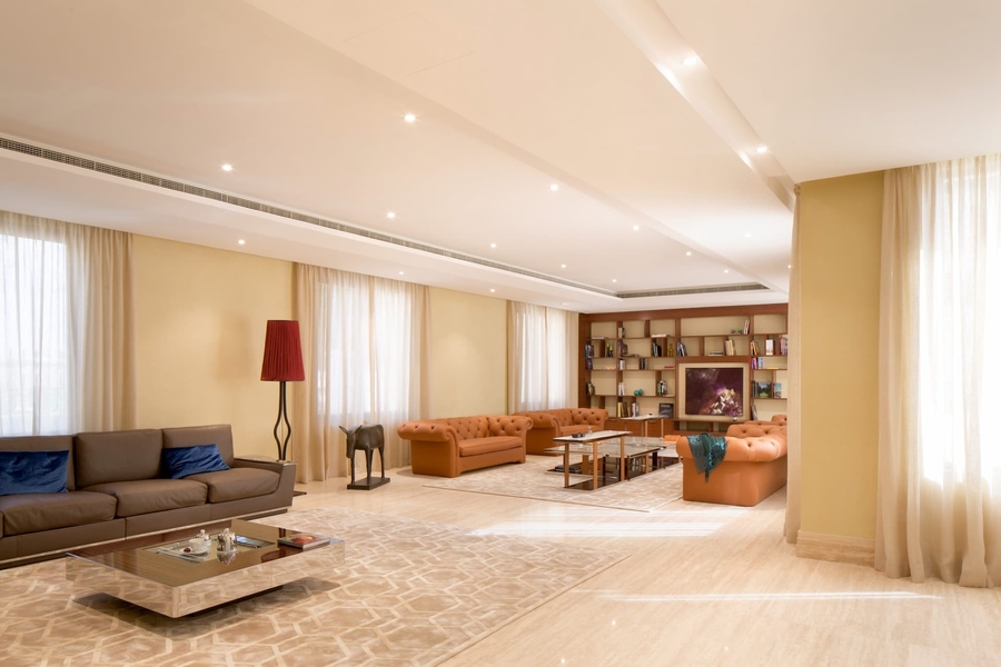 A colorful living room with bespoke sofas and center tables completed with some custom rugs.