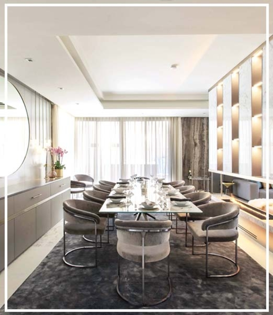 Dining room  with an open space with a glass dining table and several grey upholstery. 