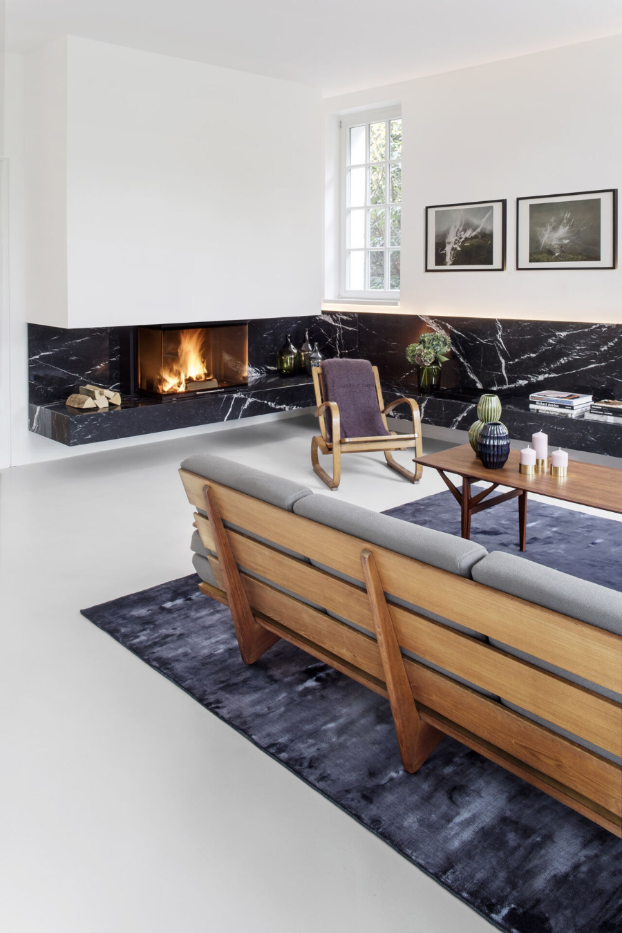 Apartment MM living area with a fireplace, a wooden rocking chair, a wooden center table and a sofa.