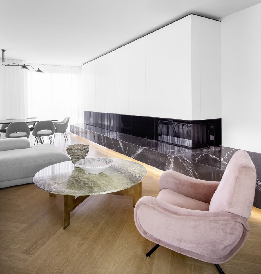 Apartment PP corner with a pink armchair, around center table, we also see a dining table behind this space.