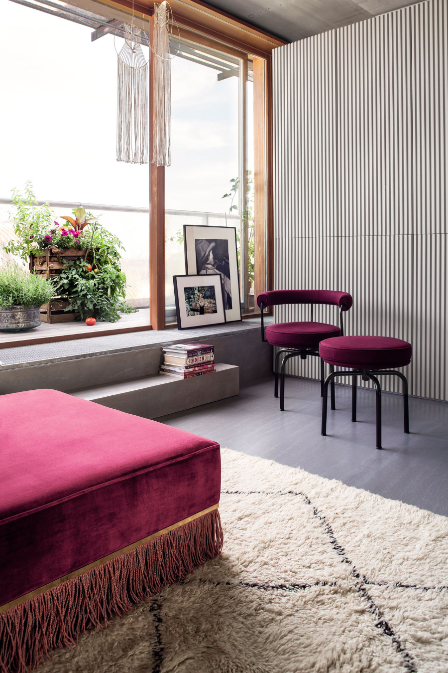 Ester apartment 2.0 reading corner in pink, with a stool and a chair next to a big window.
