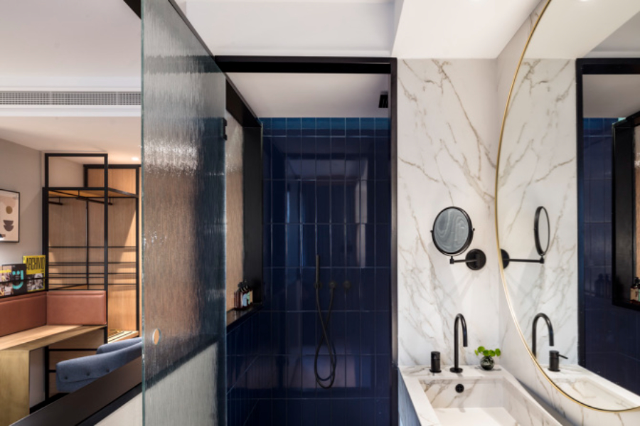 bathroom with round wall mirror and white marble sink