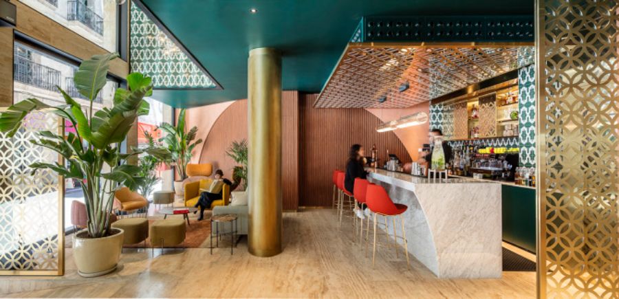 bar whit colorful furniture, red counter stools and plants