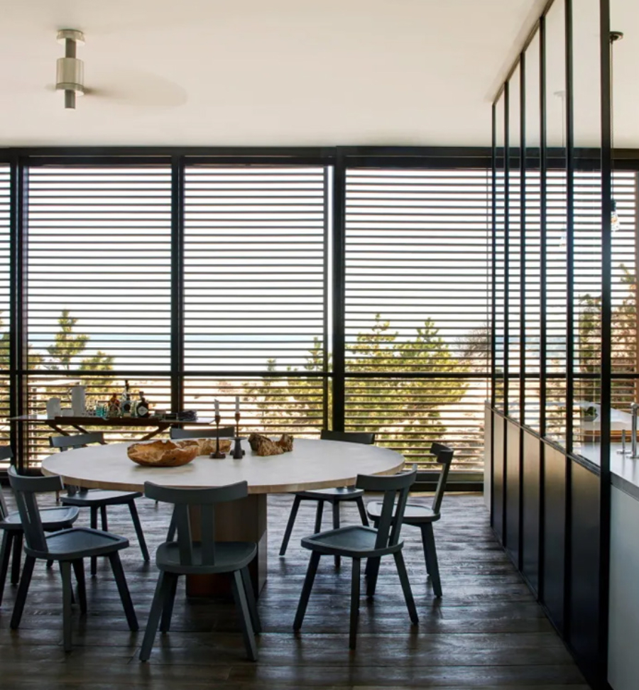 Interior Design Ideas with Yabu Pushelberg. This dining room has a big round table in wood and eight armchairs in blue. 