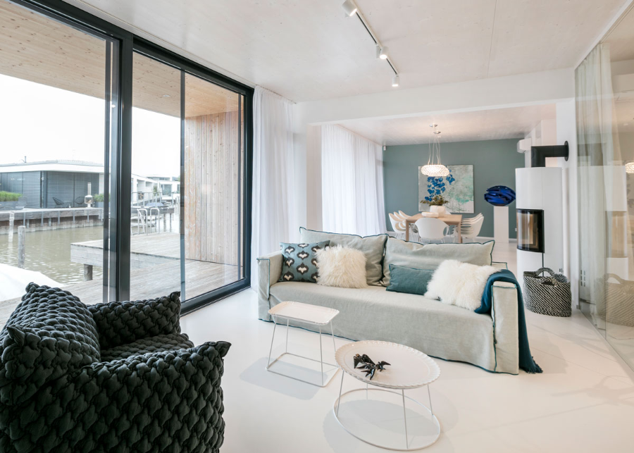 Frech Interior GmbH, haus am see living and dining room with a view of the outside.