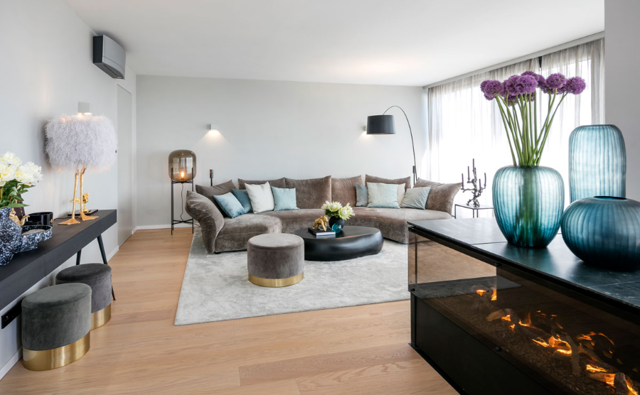 Frech Interior GmbH, penthous einterior deisgn with a brown sofa, 3 stools, on in brown and two in grey, some chandeliers and a rug