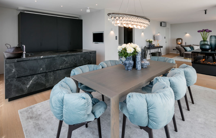 Frech Interior GmbH, dining room from the penthouse with blue dining chairs, a suspension light and a view of the kitchen