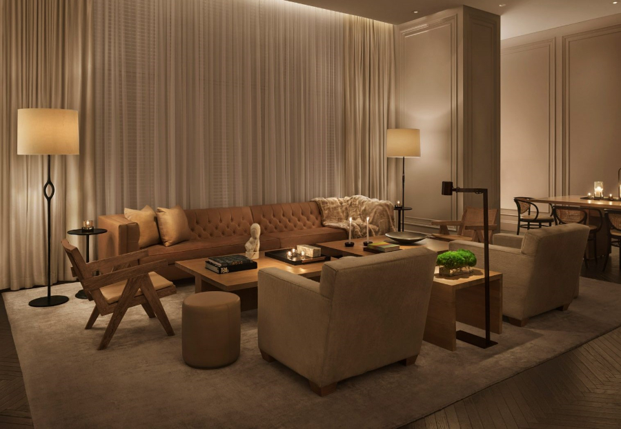 Interior Design Ideas with Yabu Pushelberg. This is a living room with neutral and brown colors. This room has one sofa in brown, two armchairs in wood, and two armchairs in neutral colors. To cover all the room is a neutral rug. 