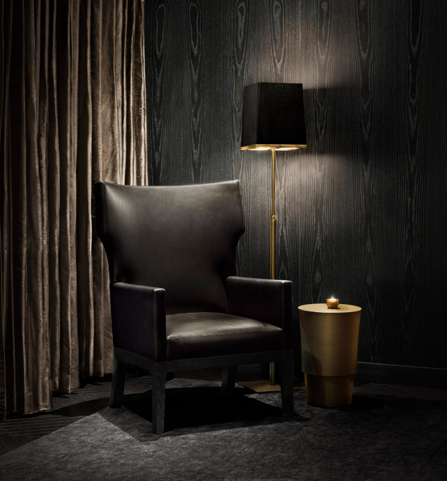 Interior Design Ideas with Yabu Pushelberg. This reading corner has a dark ambiance that combines the black armchair and the coffee table and floor light in gold details. 