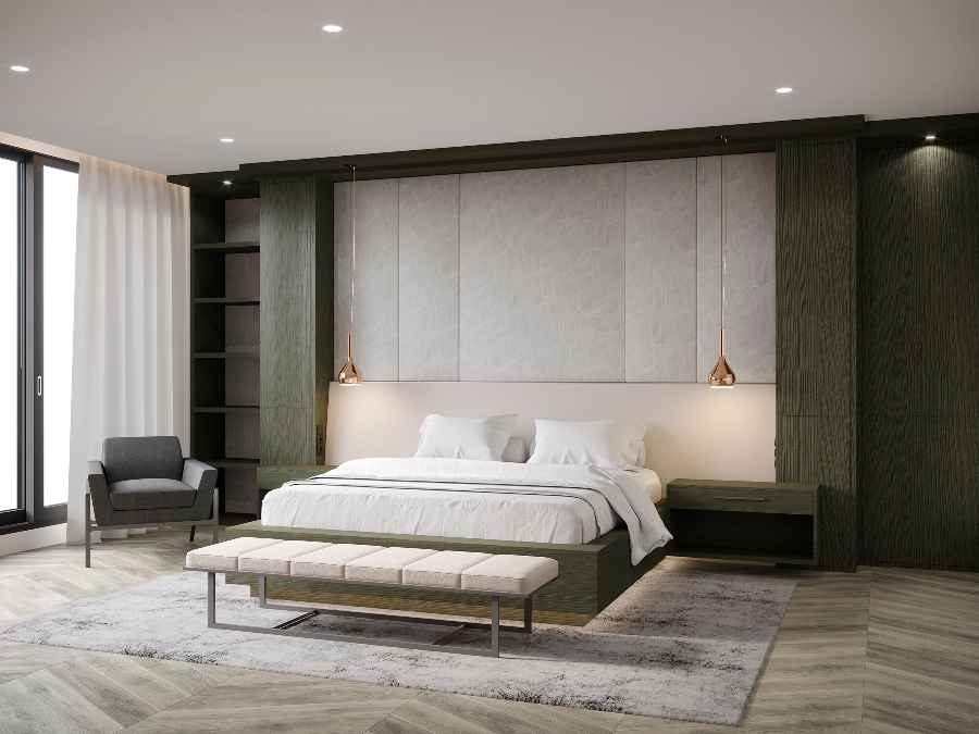 House decorating ideas by Laura Stein Interiors. This master bedroom has shelves in a dark green, white bed frame, two suspension chandeliers beside the bed, a white bench, and a grey armchair.