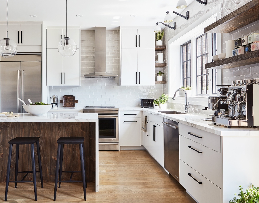 House decorating ideas by Laura Stein Interiors. This white kitchen has white cabinets, a white marble countertop, and an island in wood with a white marble countertop.