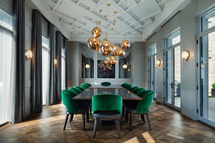 The Best Interior Design Ideas By Audax. This luxurious dining room has golden suspension chandelier, big dark dining table and velvet armchairs in green. 