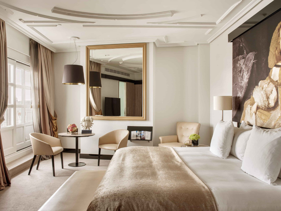 bedroom by Proffetional Finishing Design with beige bench, round center tables, rectangular mirror and beige armchairs.