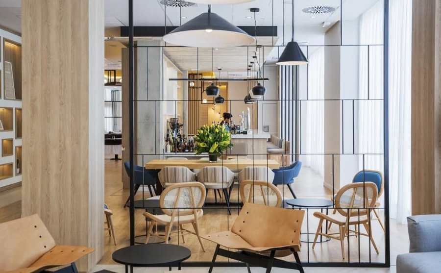 hotel dining room by Proffetional Finishing Design with brown and blue chairs, wooden dining table and black center tables