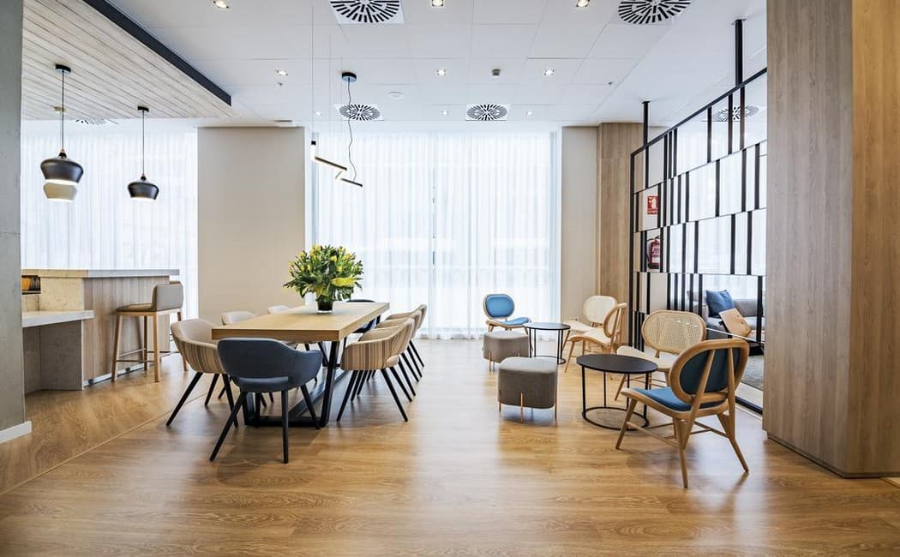 hotel dining room by Proffetional Finishing Design with brown and blue chairs, wooden dining table and black center tables