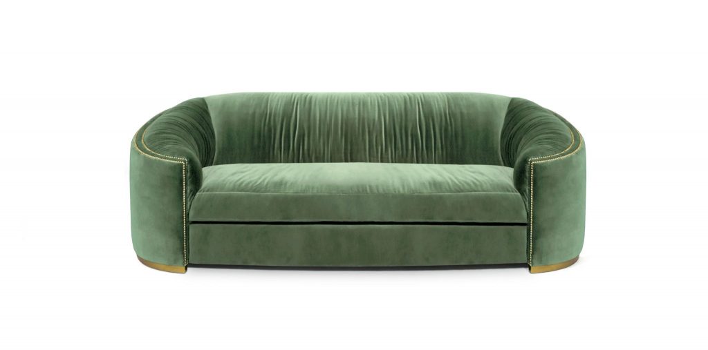 WALES Sofa, a curved velvet sofa in cotton velvet with matte vintage brass base and gold nailhead trim, adding luxury to a contemporary living room.